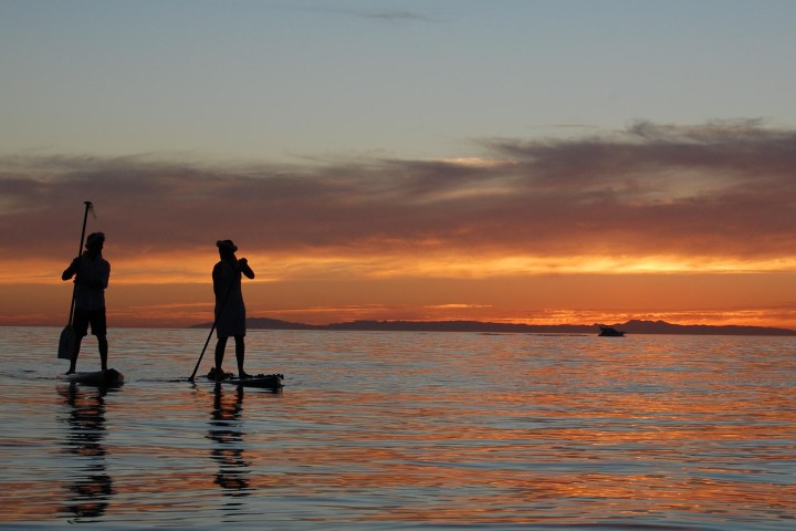 a man standing next to a body of water