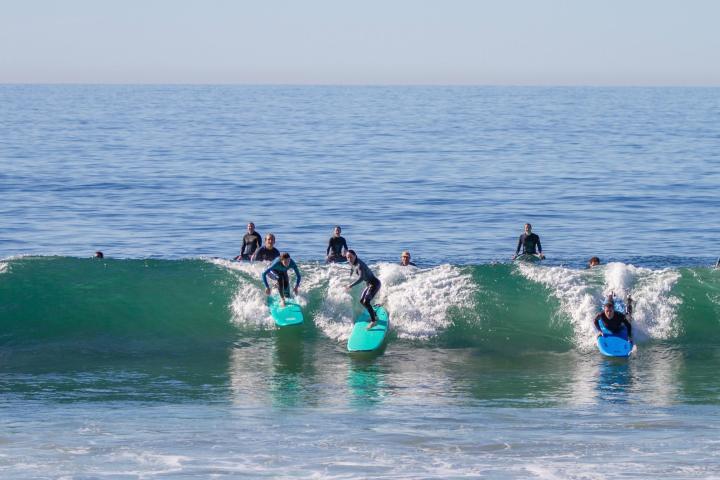 men riding a wave on a surfboard in the water