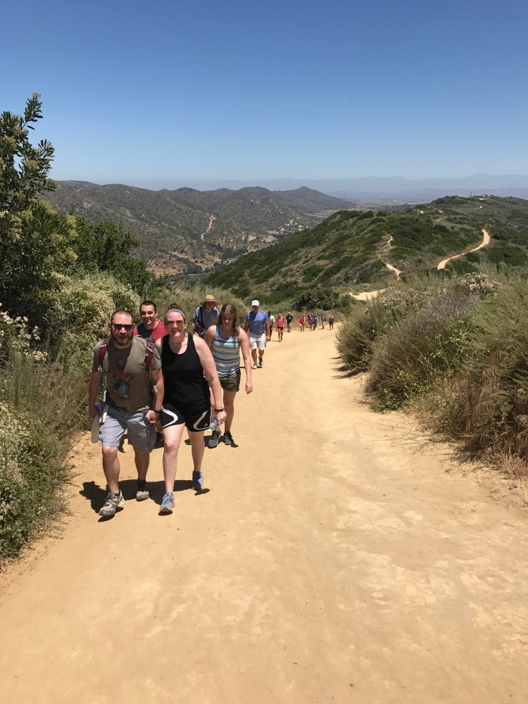 Hikers hiking uphill with scenic mountain range behind them