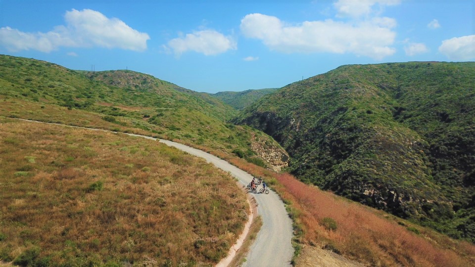 A trail through a canyon with hills in the background